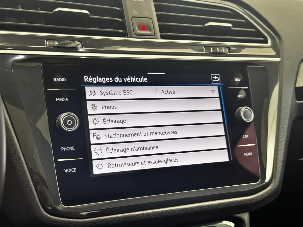 Gros plan sur l'écran tactile central du Volkswagen Tiguan 1.5 TSI 150 DSG7 Elegance affichant les réglages du véhicule.
