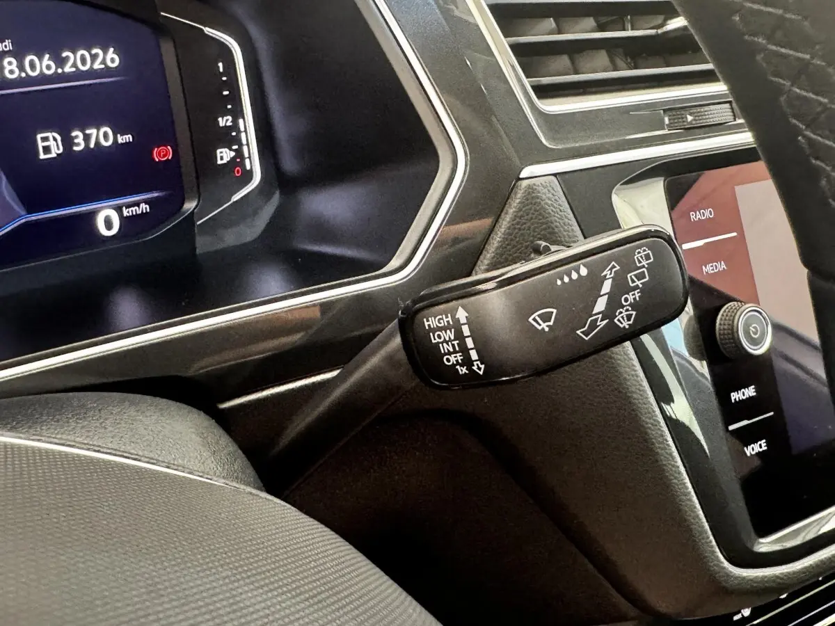 Gros plan sur la commande des essuie-glaces et le tableau de bord numérique du Volkswagen Tiguan gris clair 2021.