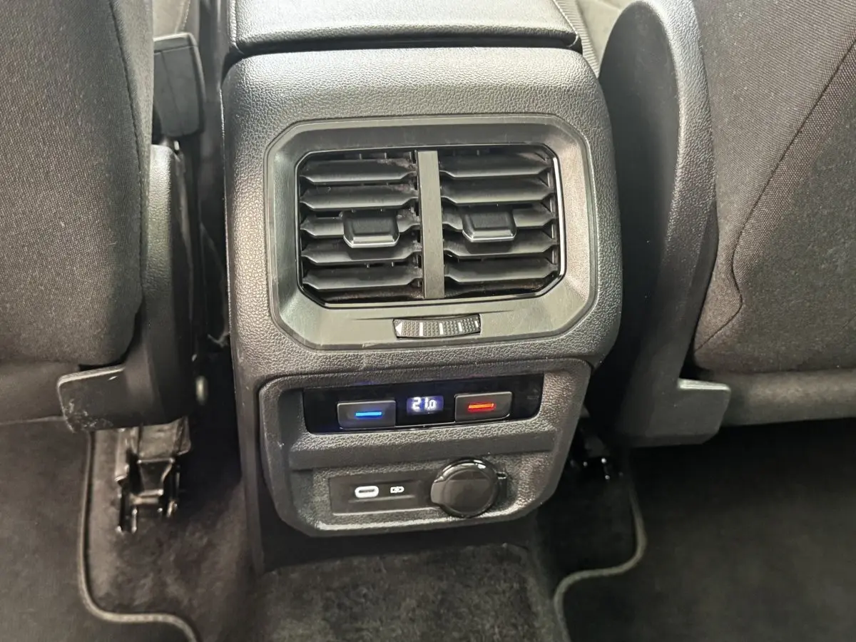 Vue rapprochée de la console arrière noire du Volkswagen Tiguan 1.5 TSI 150 DSG7 Elegance avec ventilation et commandes de climatisation digitales.