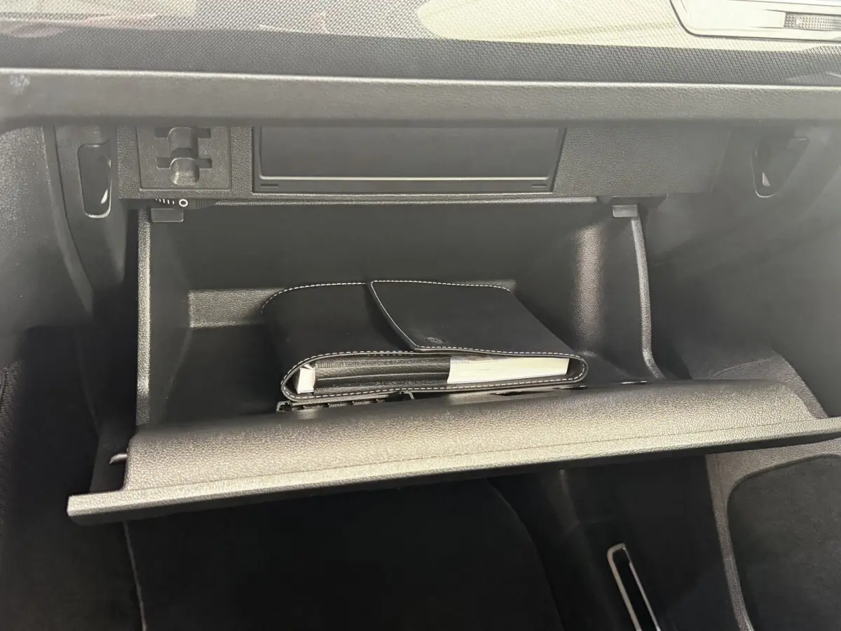 Gant de poche noir dans la boîte à gants ouverte du Volkswagen Tiguan 1.5 TSI 150 DSG7 Elegance 2021.