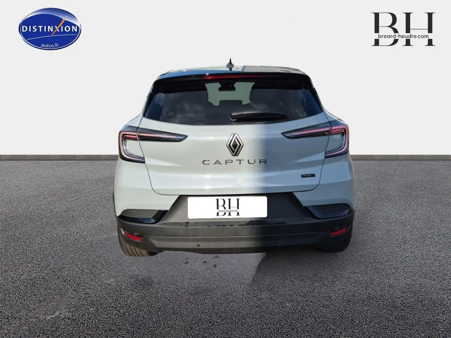 Vue arrière d'une Renault Captur blanche avec feux arrière LED et logo central bien visible.