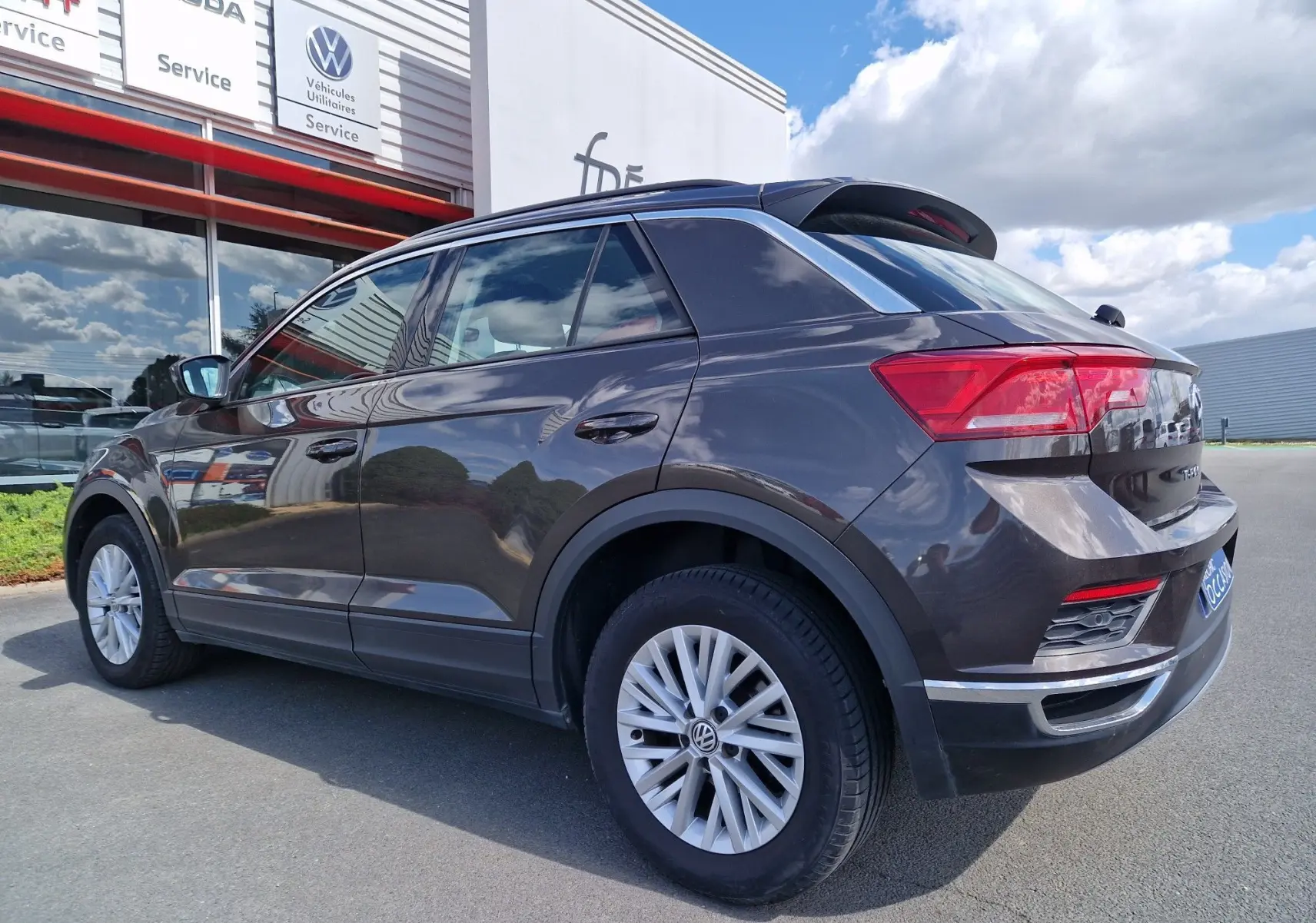 Volkswagen T-Roc chêne noir en vue 3/4 arrière droit, soulignant ses feux LED et jantes alliage.