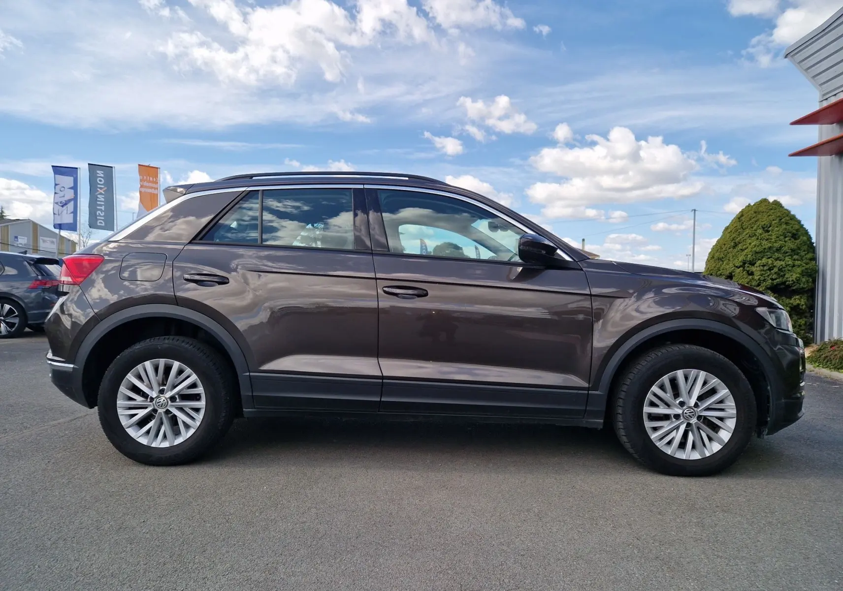 Profil côté gauche d'un Volkswagen T-Roc Chêne Noir 2.0 TDi 150 ch 4 Motion Lounge avec jantes alliage et toit noir.