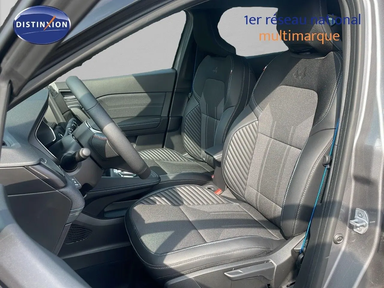 Intérieur avant droit du Renault Captur gris Cassiopée, sièges noirs avec surpiqûres et logo Alpine brodé.