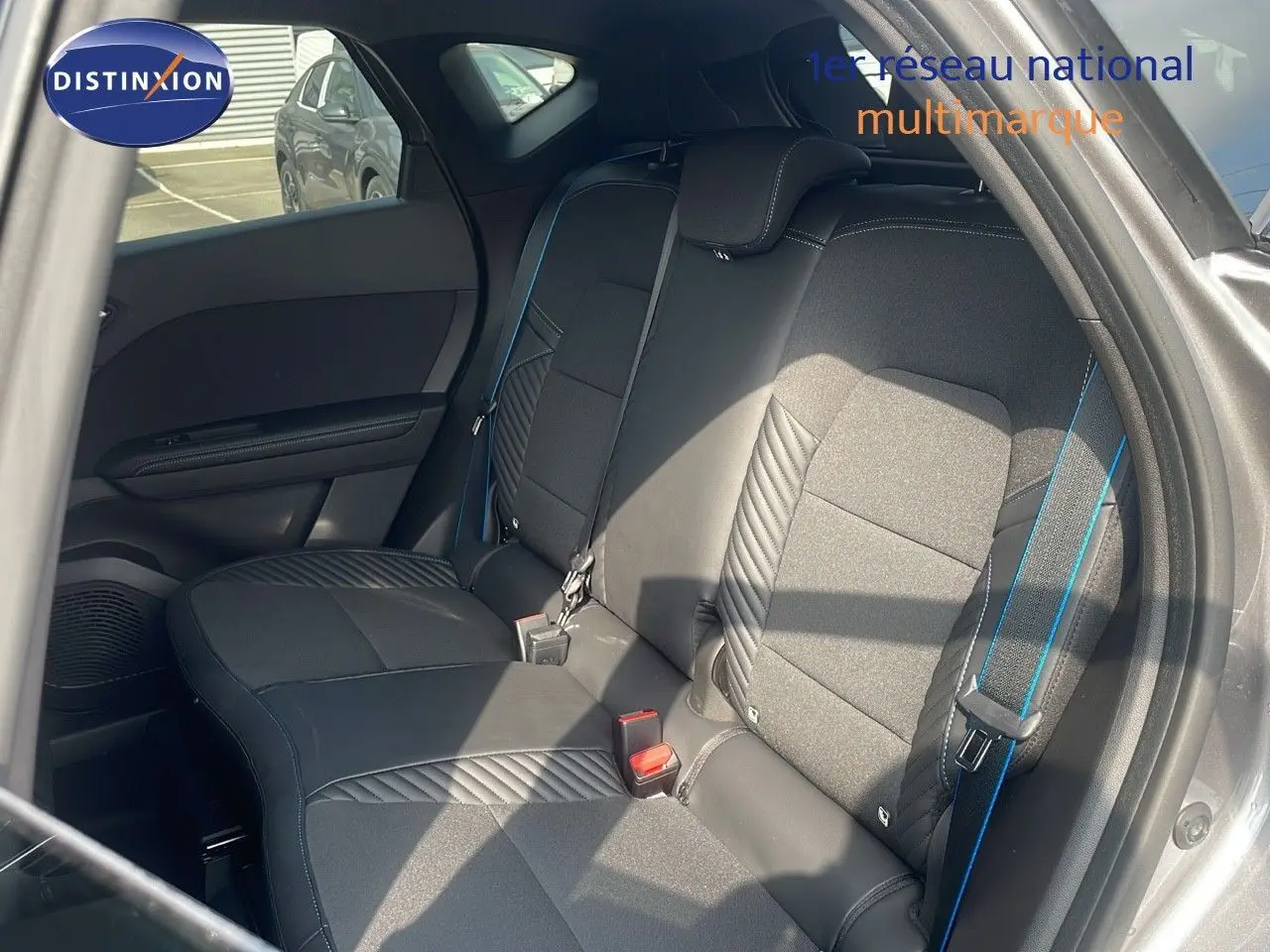Vue intérieure côté gauche des sièges arrière noirs avec surpiqûres bleues du Renault Captur E-Tech hybride 2025.