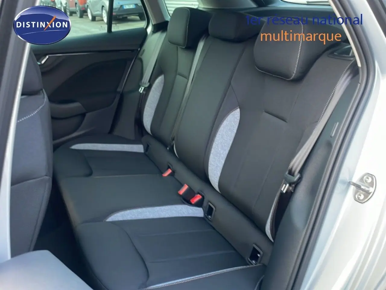 Vue intérieure côté droit montrant la banquette arrière bi-ton noir et gris clair d'une Skoda Kamiq gris argent.