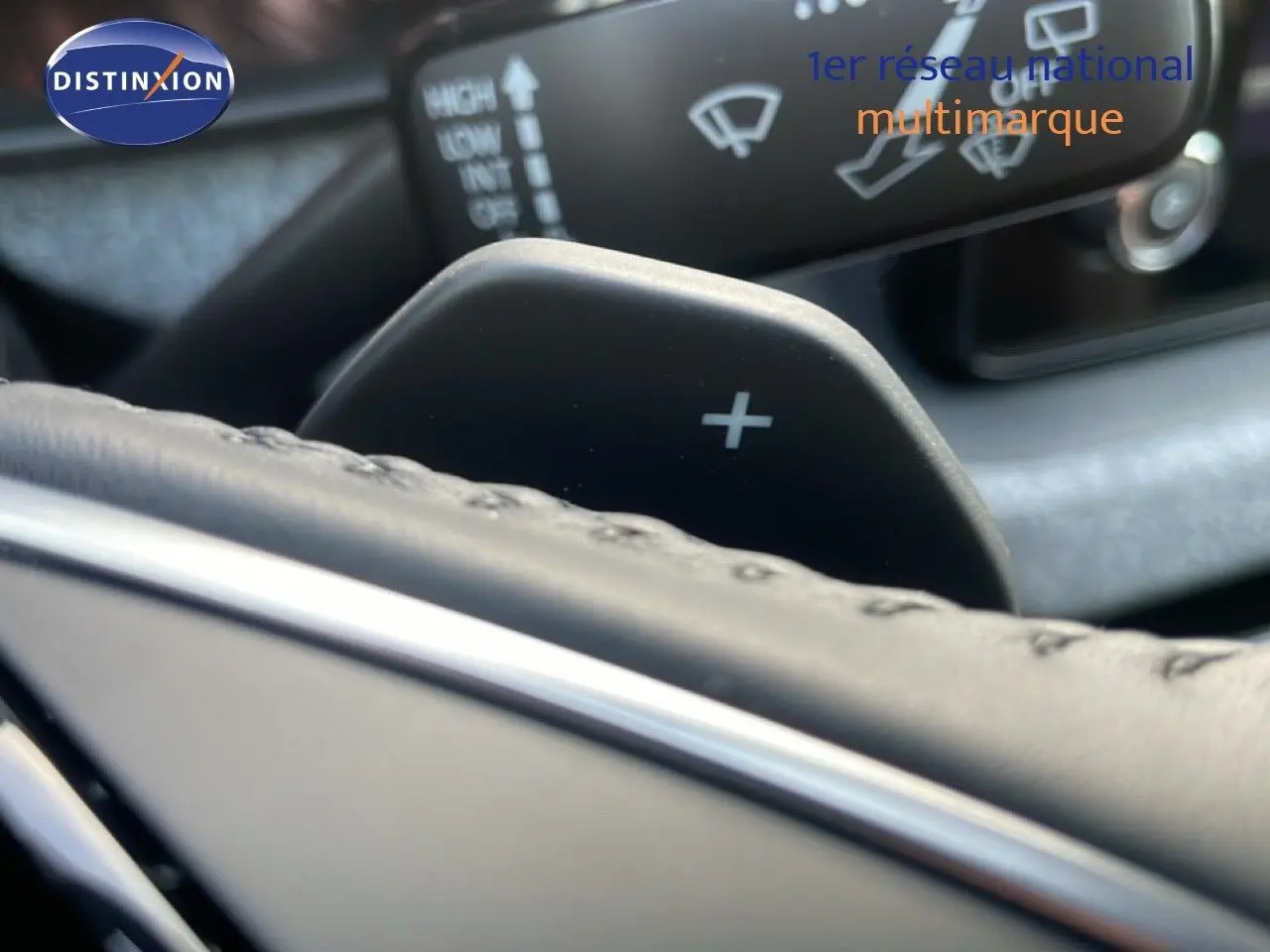 Gros plan sur la palette de changement de vitesse "+" derrière le volant du Skoda Kamiq gris argent métal.