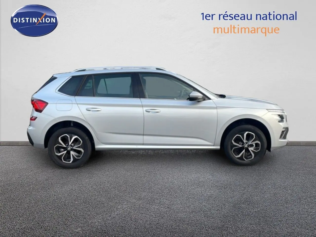 Vue de profil côté gauche d'un Skoda Kamiq gris argent métallisé avec jantes biton et cinq portes.