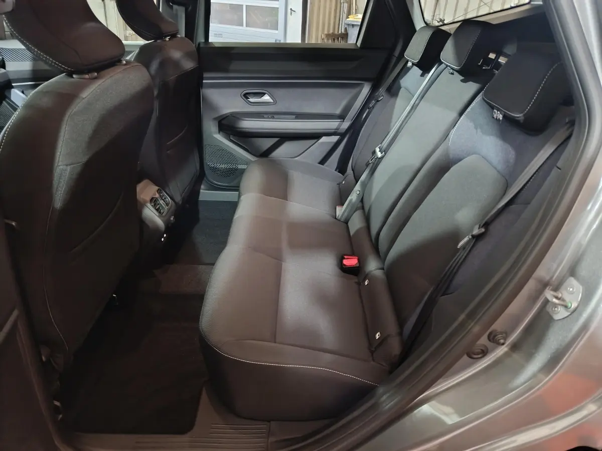 Vue intérieure côté droit sur la banquette arrière noire du Dacia Bigster gris foncé avec ceinture et appuie-têtes visibles.