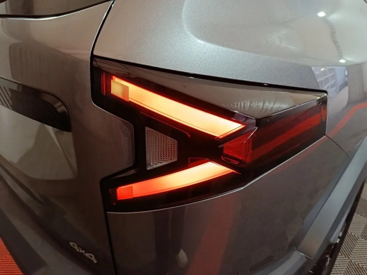 Gros plan sur le feu arrière droit rouge et orange du Dacia Bigster gris foncé 4x4, soulignant son design anguleux.