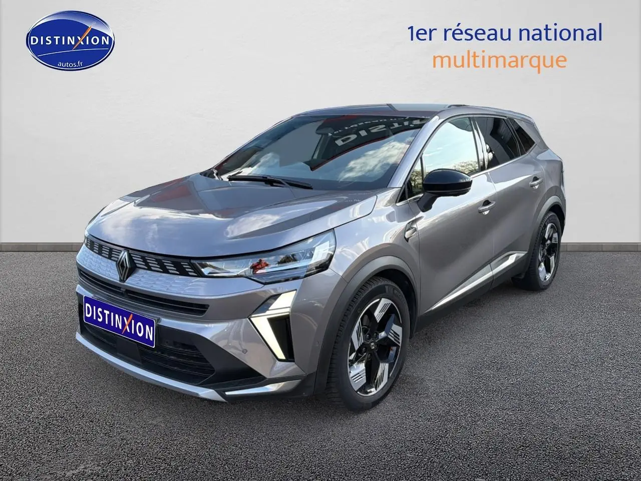 Renault Symbioz 2025 gris métallisé en 3/4 avant droit, avec calandre moderne et jantes noires distinctives.