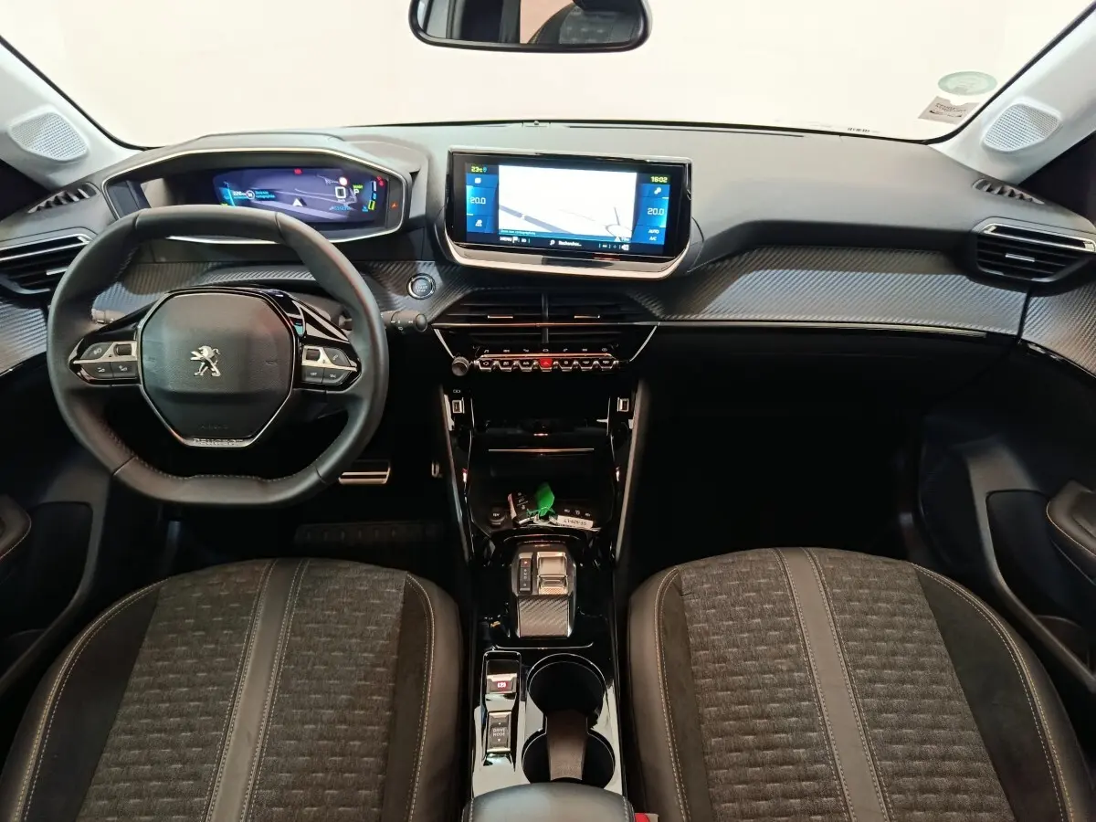 Vue intérieure avant du tableau de bord et volant cuir noir de la Peugeot 208 Electrique Roadtrip 2022.