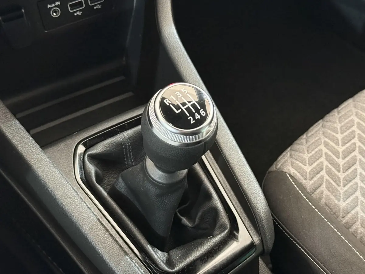 Le levier de vitesses manuel noir de la Renault Clio Evolution TCe 100 GPL, avec indication des 6 rapports, vue rapprochée intérieure.