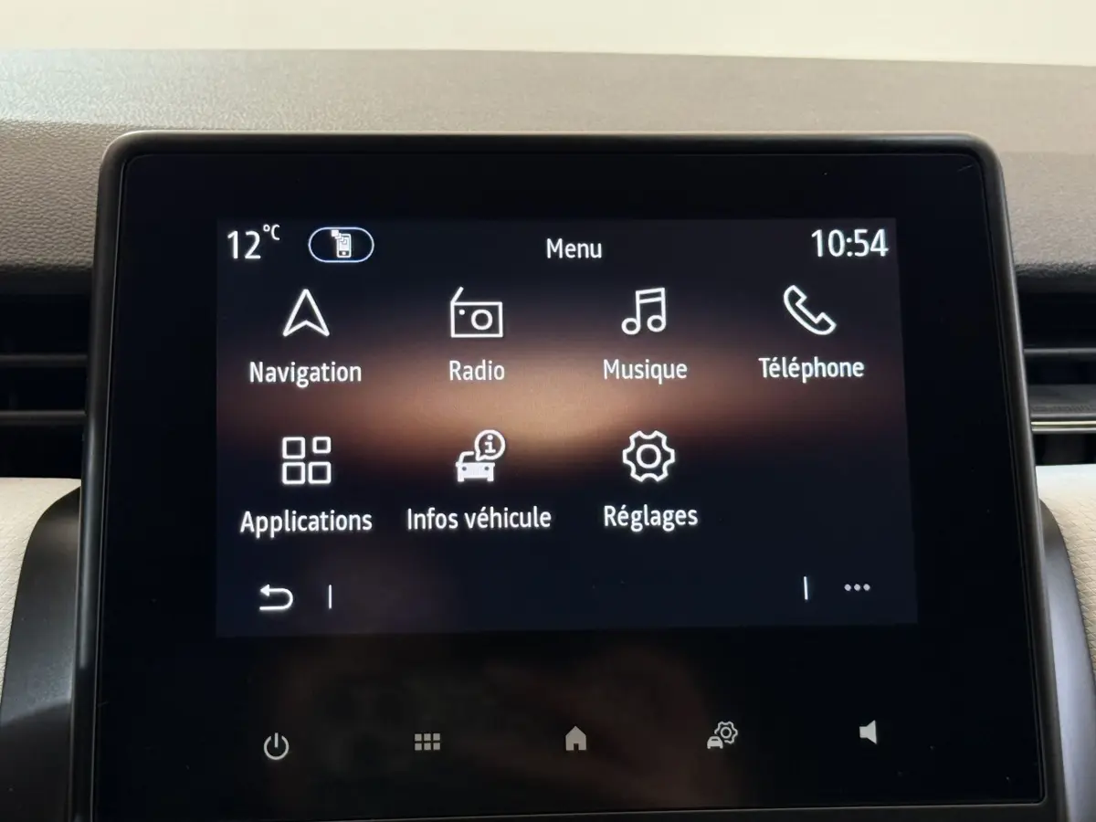 Écran tactile central de la Renault Clio blanc, affichant le menu principal avec navigation et radio à 10h54.