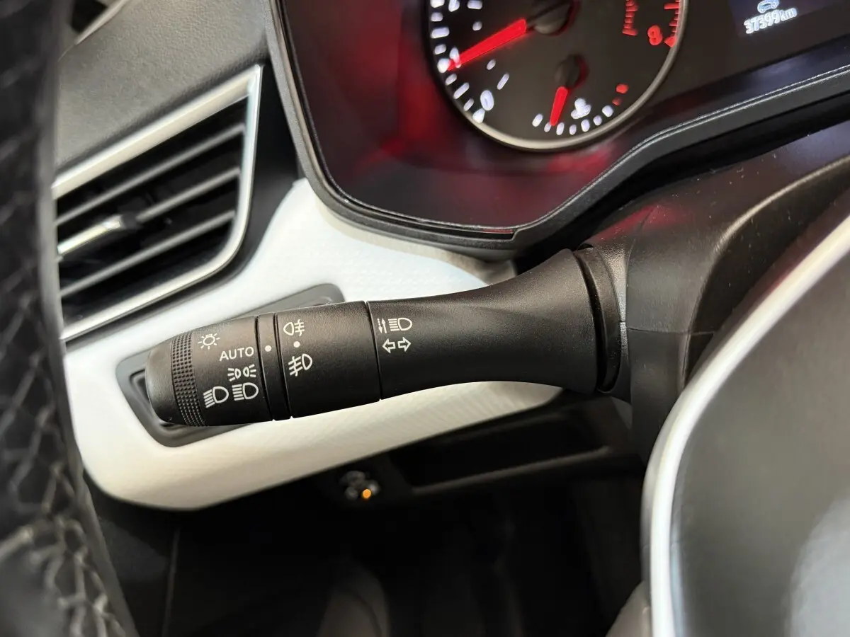 Gros plan sur la commande des feux et clignotants côté gauche du tableau de bord de la Renault Clio blanc 2023.