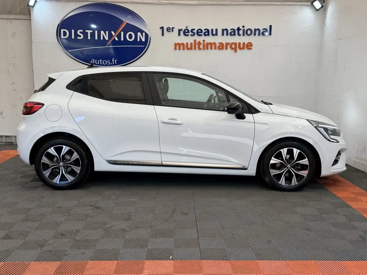 Profil droit d'une Renault Clio blanche 2023 Evolution TCe 100 GPL avec jantes alliage et rétroviseurs noirs.