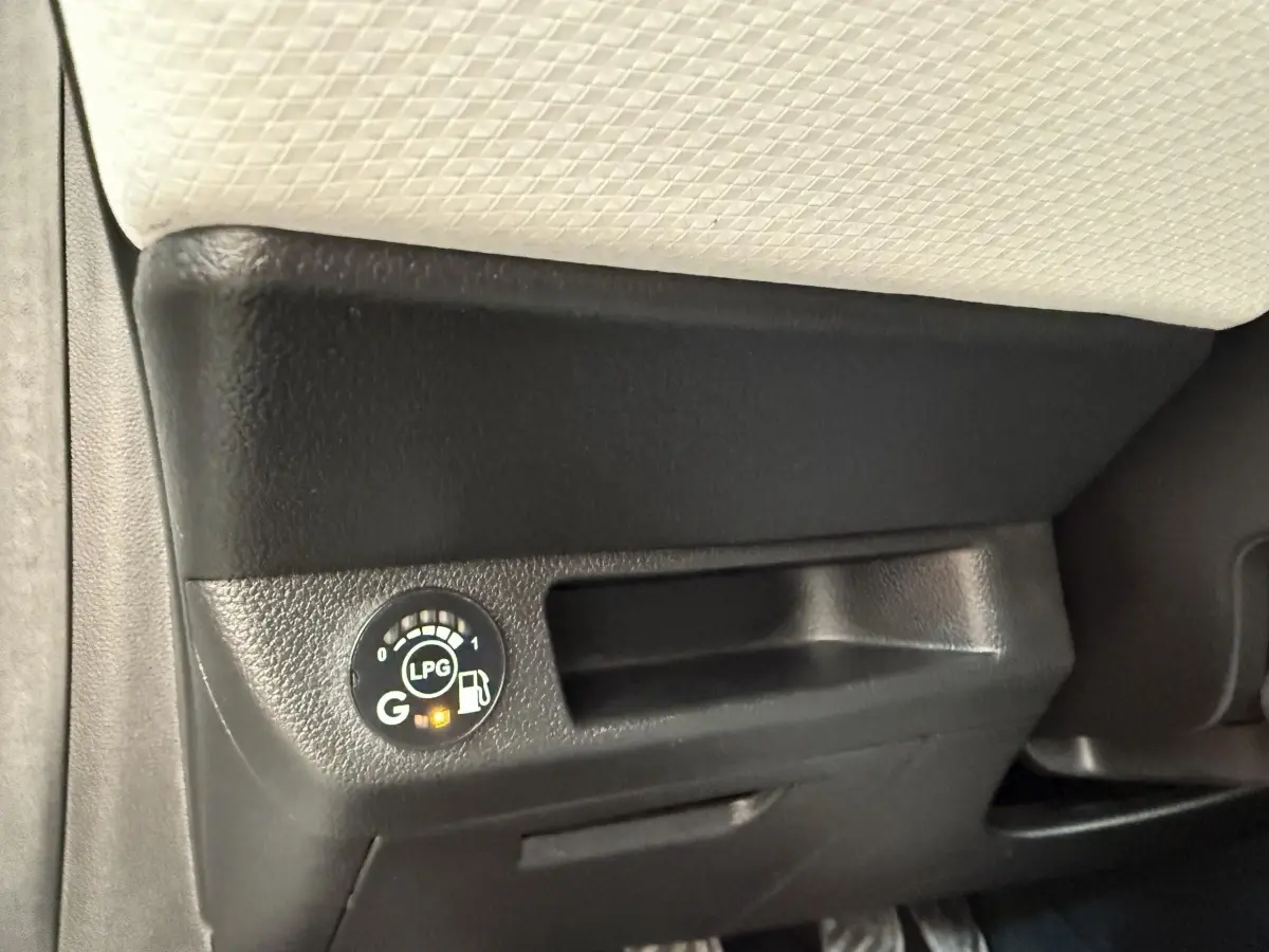 Gros plan sur le tableau de bord noir avec indicateur de carburant GPL allumé dans une Renault Clio blanche.