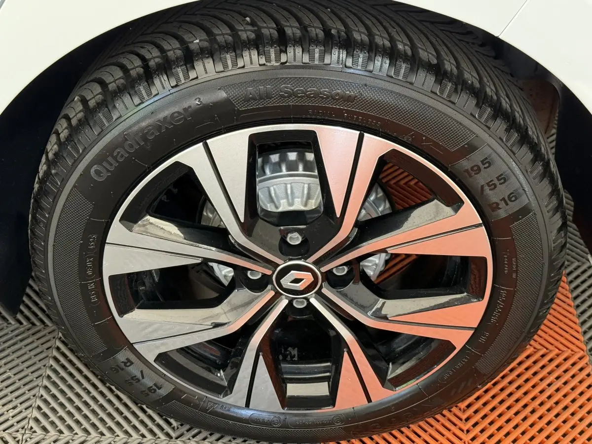 Gros plan sur la jante alliage bicolore noire et argentée de la Renault Clio blanche Evolution TCe 100 GPL.