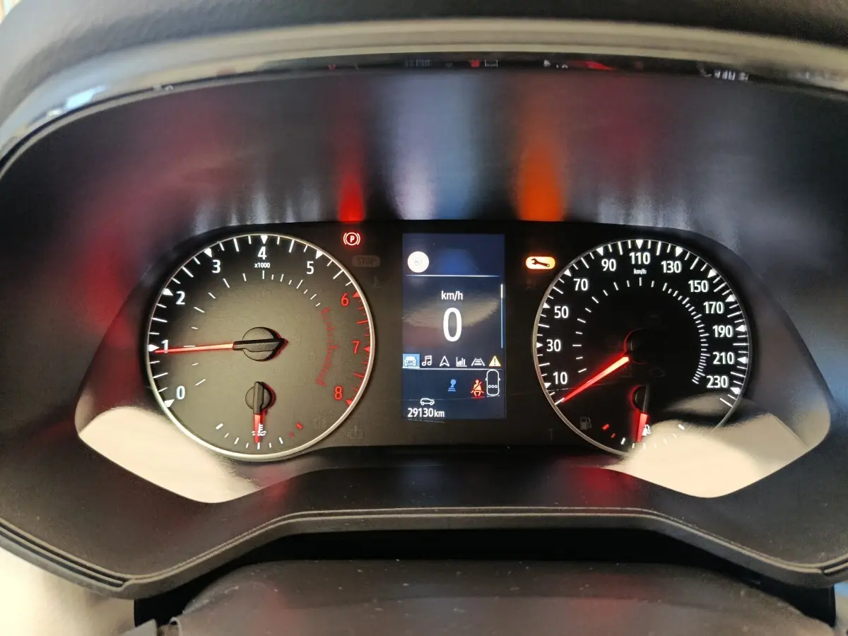 Vue rapprochée du tableau de bord de la Renault Clio blanc 2023, affichage digital et compte-tours analogiques.