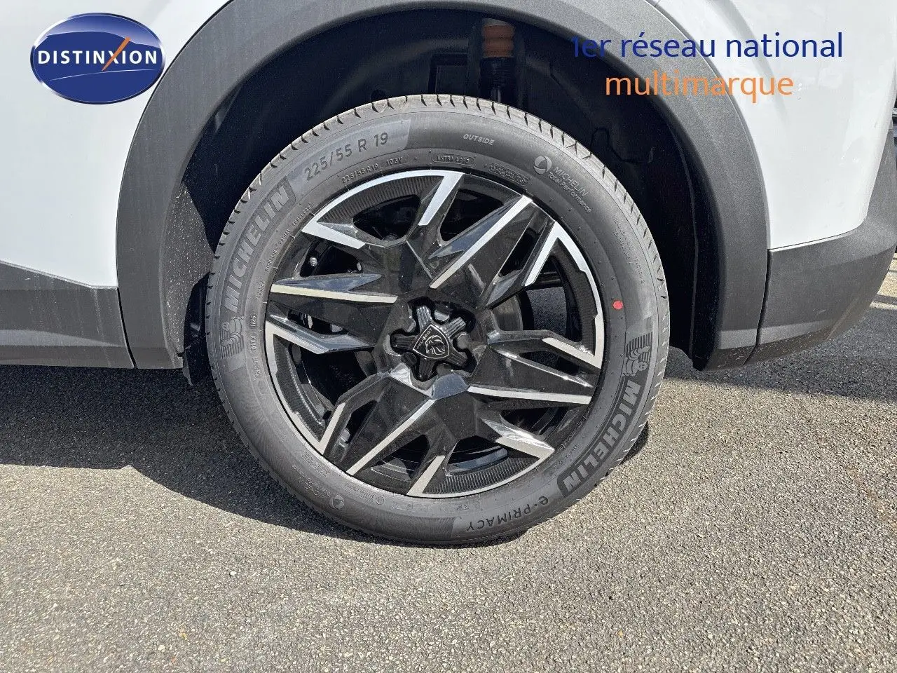 Gros plan sur la roue avant droite du Peugeot 3008 blanc Okenite avec jante noire et argentée design moderne.
