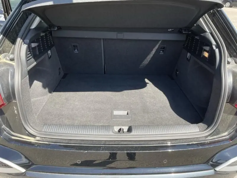 Coffre ouvert vu de l'arrière d'un Audi Q2 noir métal 2022, montrant un espace de chargement propre et spacieux.