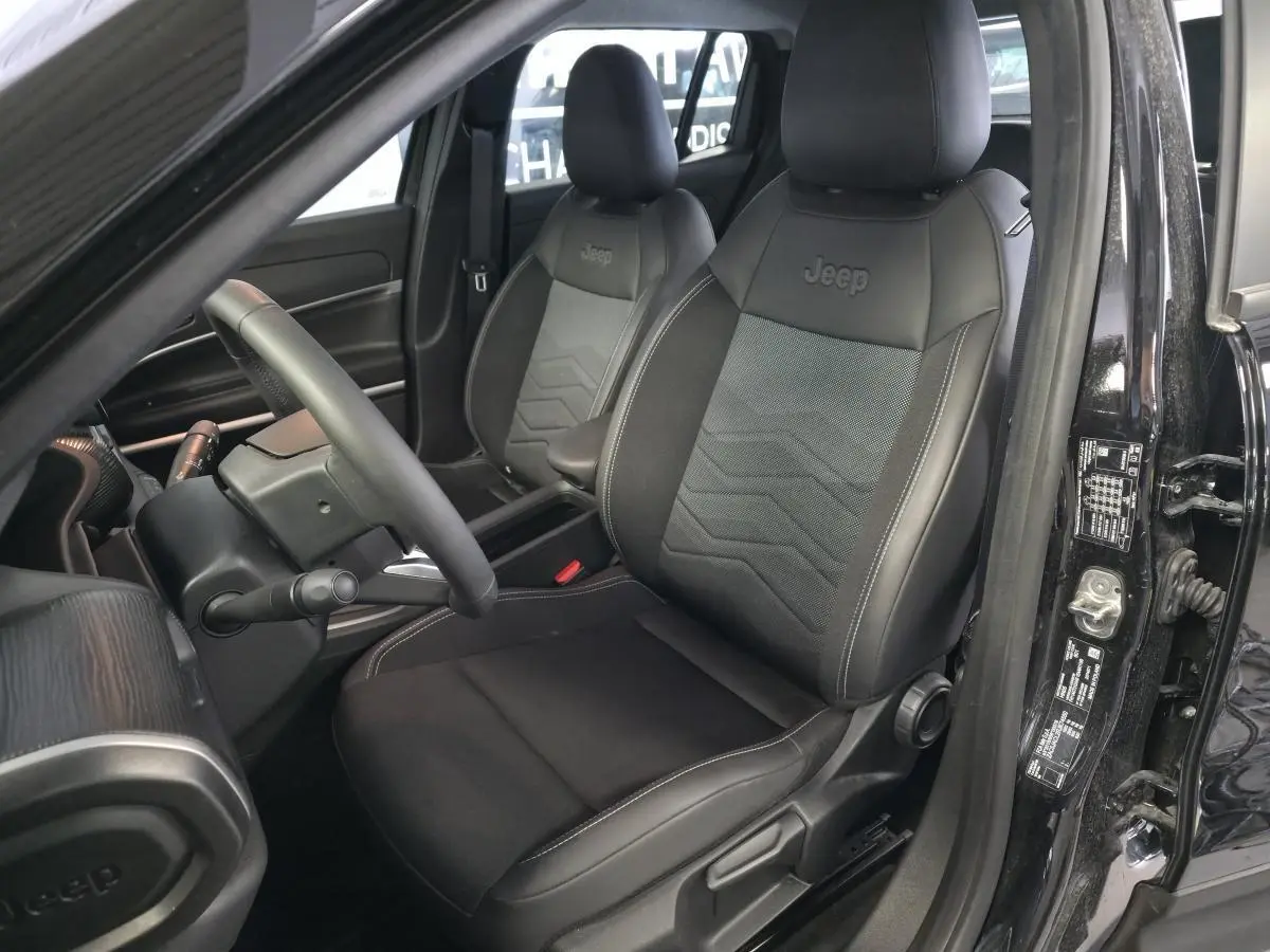 Intérieur noir du Jeep Avenger 2024, vue côté conducteur sur sièges mixte tissu/TEP avec logo Jeep brodé.