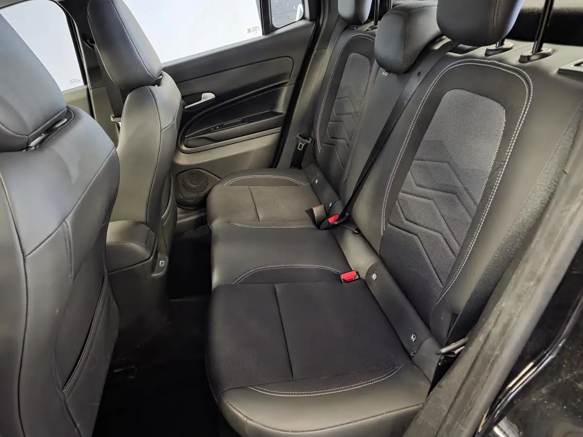 Vue côté droit de la banquette arrière noire en tissu et TEP du Jeep Avenger 2024 avec détails gris et ceintures rouges.