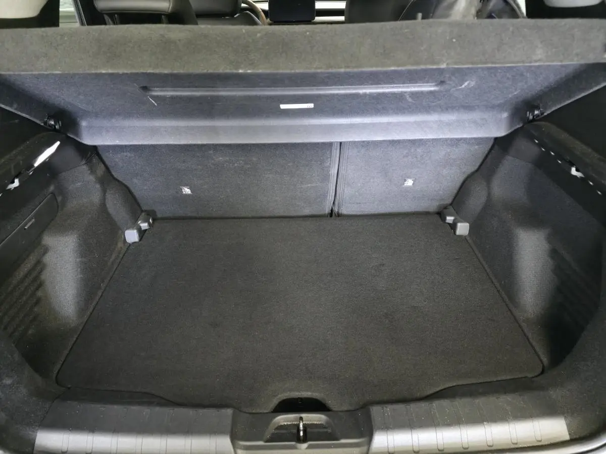 Coffre ouvert du Jeep Avenger noir 2024, montrant l'espace de chargement avec banquette arrière rabattable.