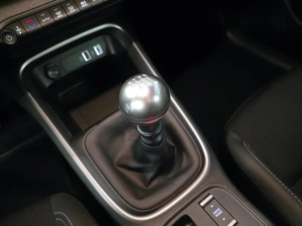 Le levier de vitesses manuel en TEP noir avec pommeau métallique dans l'habitacle du Jeep Avenger 2024 noir.