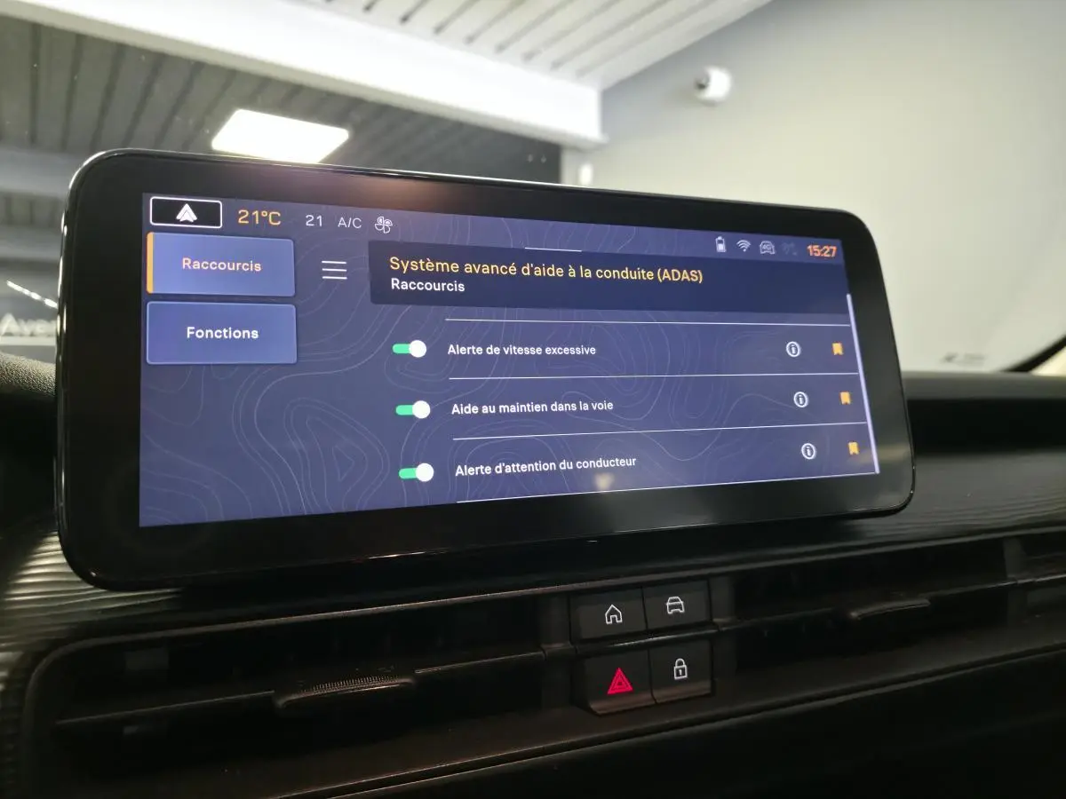 Écran tactile Uconnect 10,25" affichant les aides à la conduite dans l'habitacle du Jeep Avenger noir.