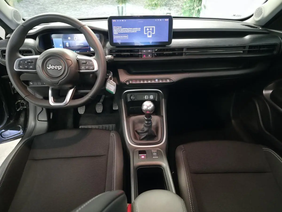 Intérieur du Jeep Avenger 2024 avec volant Jeep, tableau de bord numérique et levier de vitesses manuel en TEP noir.