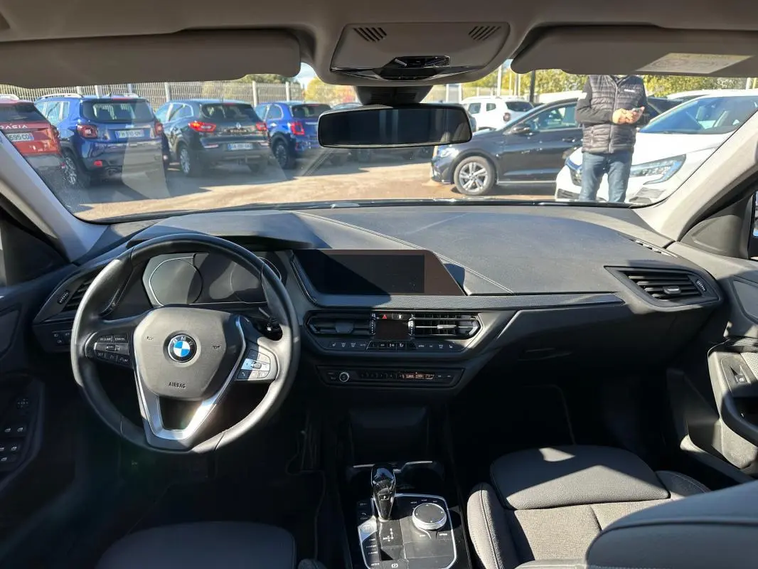 Intérieur noir de BMW Série 1 F40 118d 2021, vue frontale du tableau de bord et volant cuir sport avec commandes intégrées.