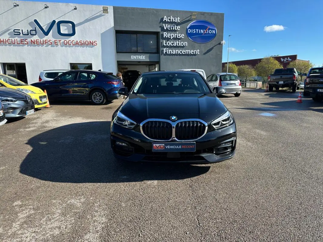 BMW Série 1 F40 118d noire vue de face, avec calandre double haricot et phares LED distinctifs.