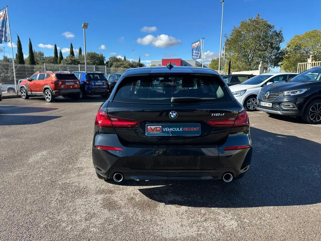 Vue arrière d'une BMW Série 1 noire F40 118d avec double sortie d'échappement et feux arrière LED.