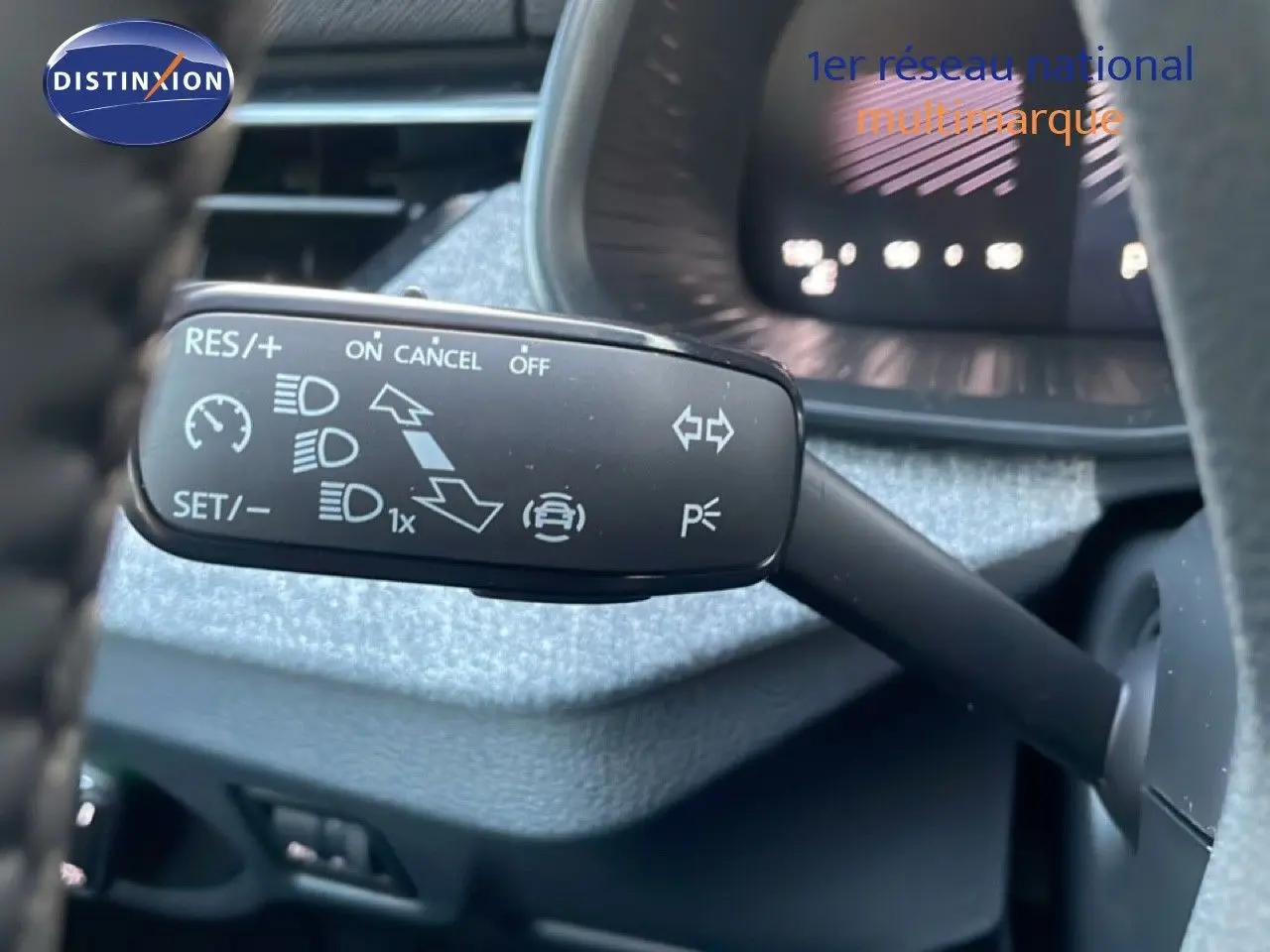 Gros plan sur la commande de régulateur de vitesse et feux du Skoda Kamiq, intérieur avec tableau de bord gris.