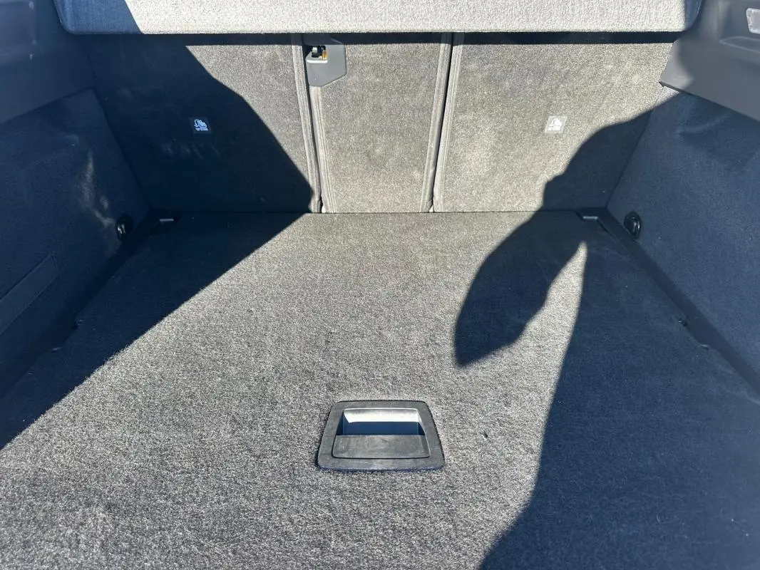 Coffre spacieux et vide du Peugeot 3008 Hybrid blanc, vue intérieure depuis l'ouverture arrière.