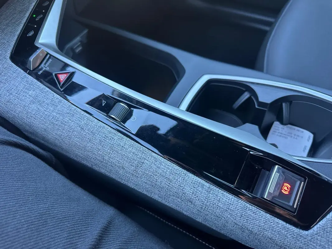 Gros plan sur la console centrale du Peugeot 3008 Hybrid 145 Allure 2025, avec frein de parking électrique activé.
