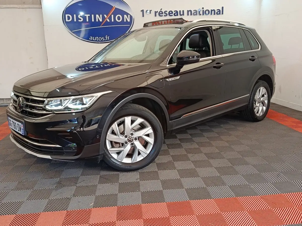 Volkswagen Tiguan noir hybride rechargeable vu en 3/4 avant droit, avec jantes alliage et badge eHybrid visible.