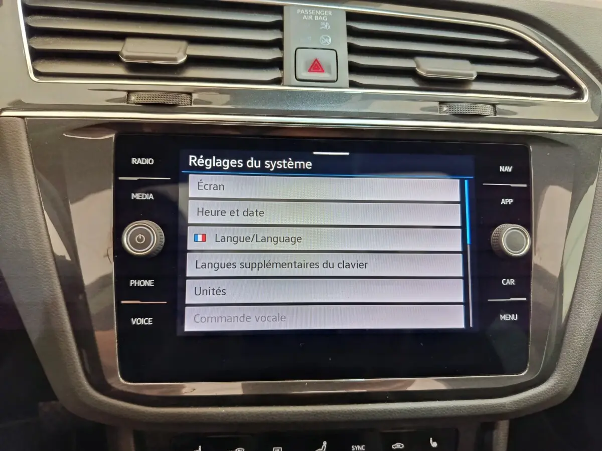 Vue rapprochée de l'écran tactile central du Volkswagen Tiguan noir, affichant les réglages du système.