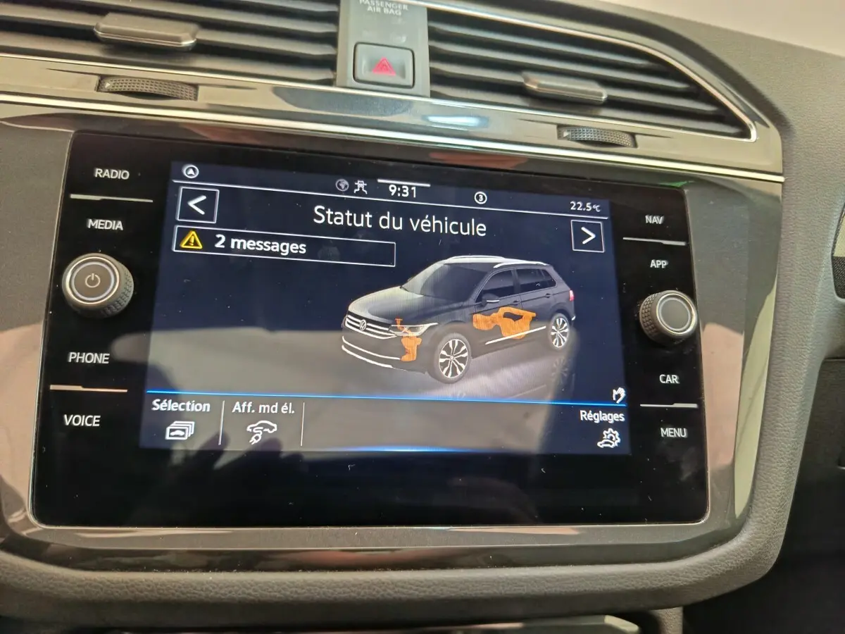 Écran tactile intérieur affichant le statut du Volkswagen Tiguan noir, avec alertes et schéma du véhicule en vue latérale.