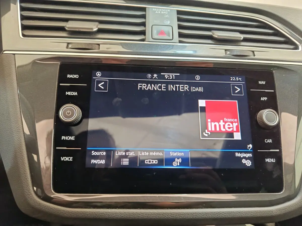 Vue rapprochée de l’écran tactile noir du système multimédia du Volkswagen Tiguan 2022 affichant la radio France Inter.