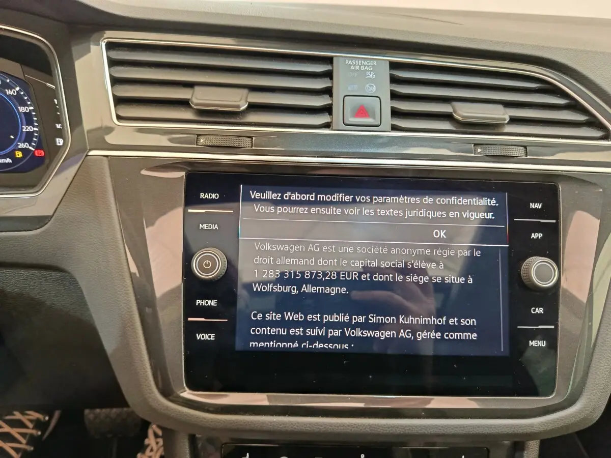 Vue rapprochée de la console centrale du Volkswagen Tiguan 2022 noir, avec écran tactile affichant un message de confidentialité.