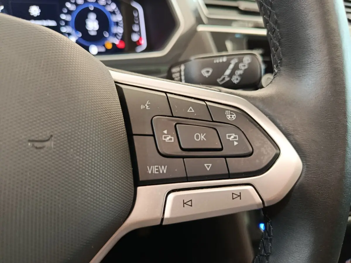 Gros plan sur les commandes multifonctions à droite du volant cuir noir du Volkswagen Tiguan 1.4 eHybrid 2022.