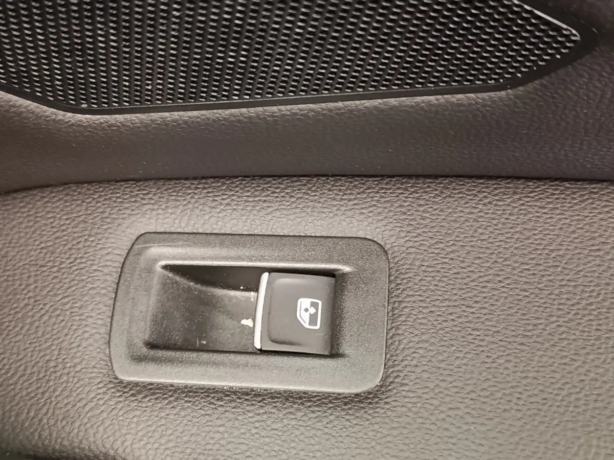 Gros plan sur le bouton de commande de vitre électrique sur la porte intérieure noire d’un Volkswagen Tiguan 2022.