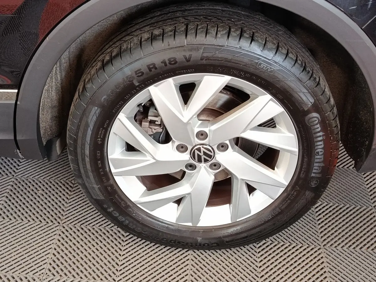 Gros plan sur la roue avant droite du Volkswagen Tiguan noir, mettant en valeur la jante alliage argentée et le pneu Continental.