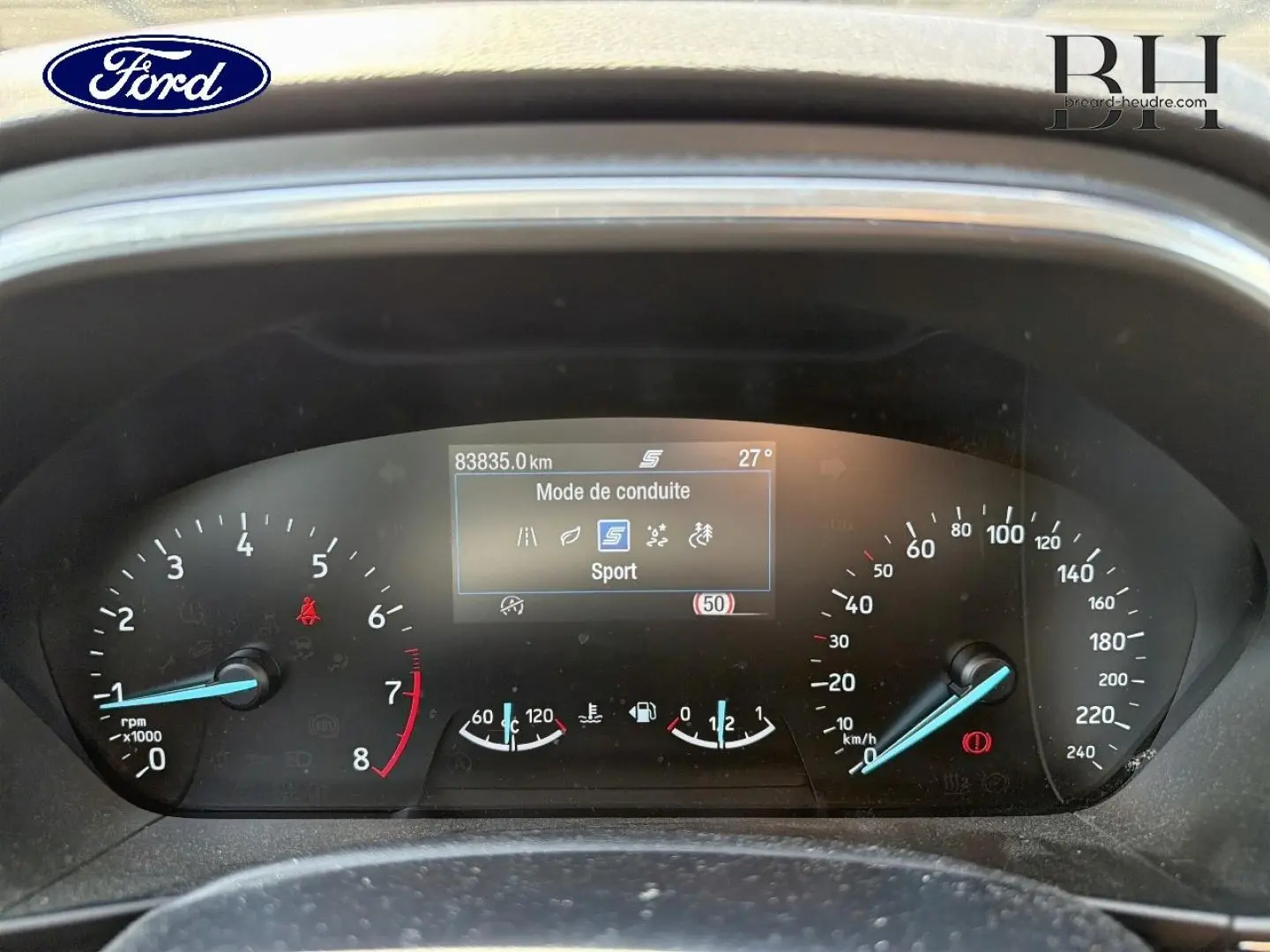 Tableau de bord de Ford Focus noir, vue frontale du combiné d'instruments avec affichage mode Sport et compteurs analogiques.