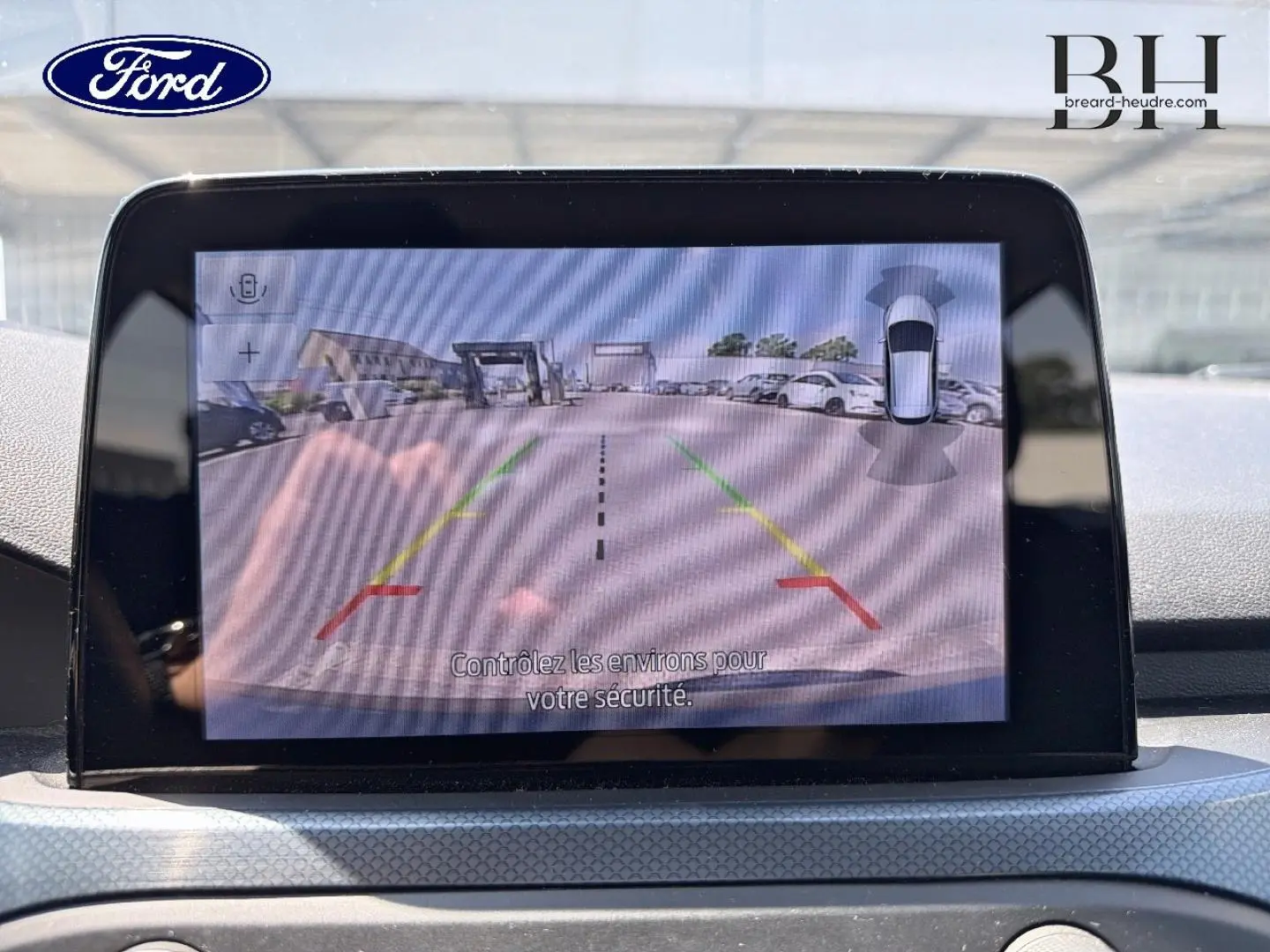 Écran tactile intérieur montrant la caméra de recul avec guidage coloré sur Ford Focus noir Agate 2021.