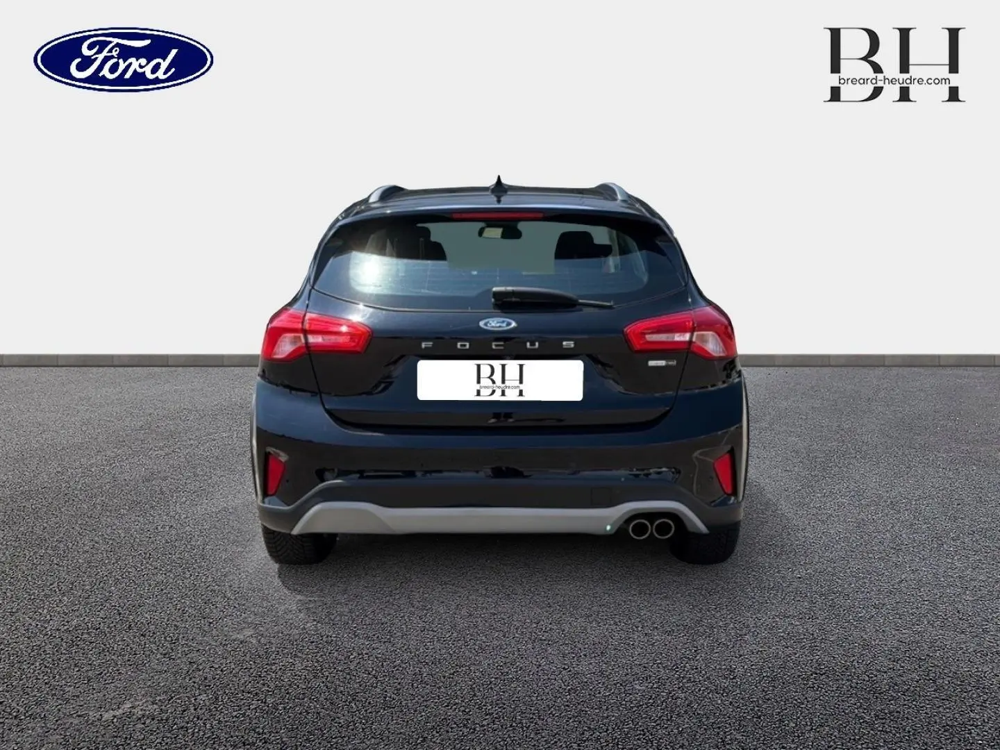 Vue arrière d'une Ford Focus noire Agate métallisé 2021 avec double sortie d'échappement et barres de toit visibles.