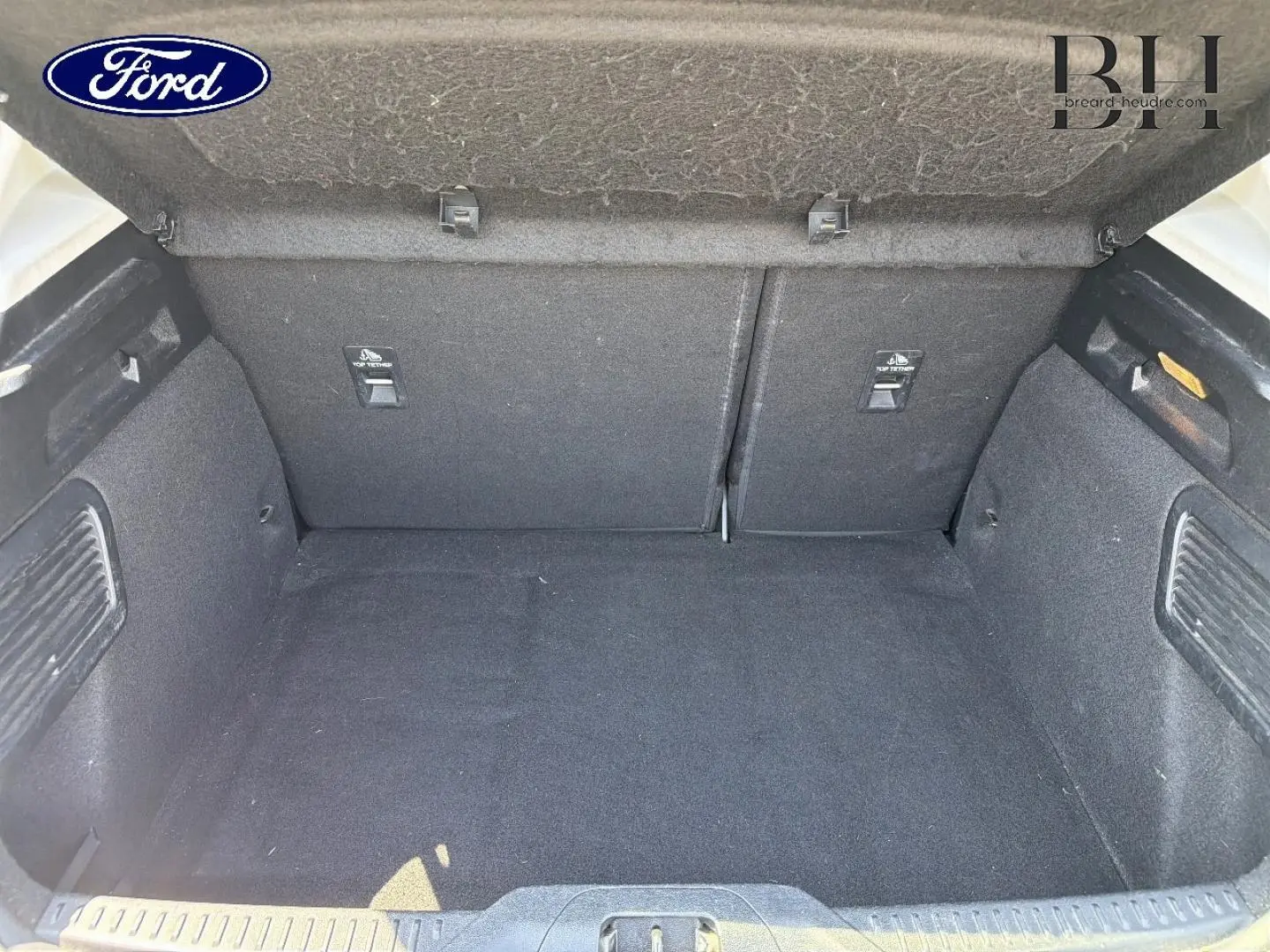 Vue intérieure du coffre spacieux et propre de la Ford Focus 2021, revêtement tissu noir uniforme.