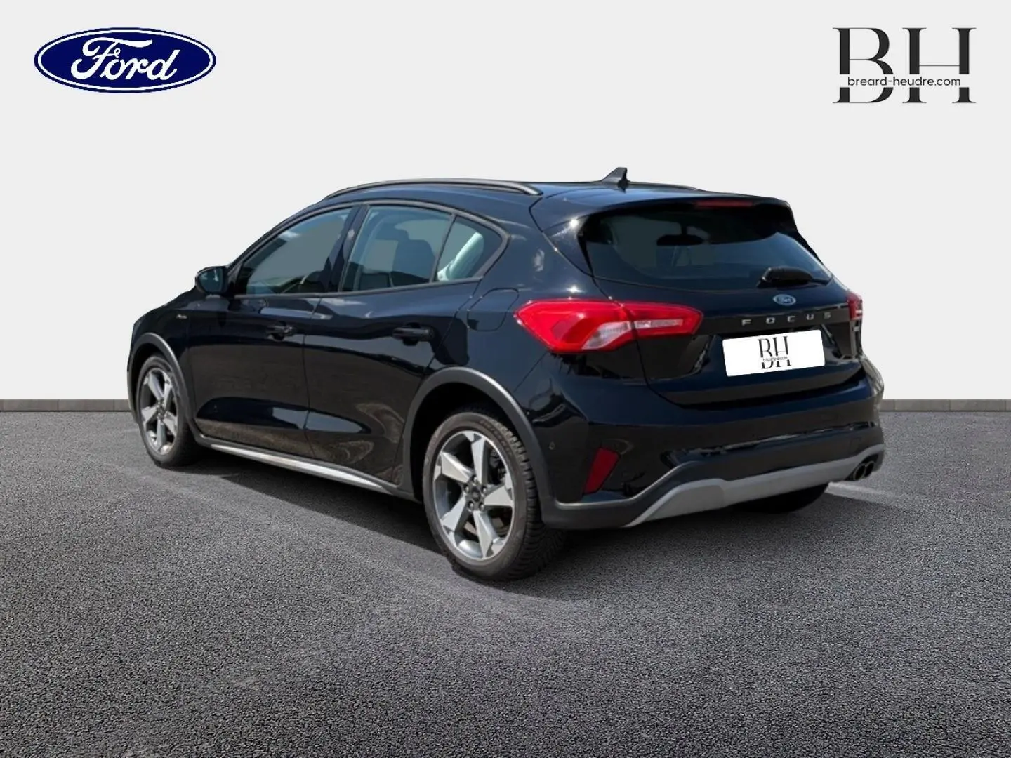 Vue 3/4 arrière gauche d'une Ford Focus 2021 noir Agate métallisé avec jantes alliage et barres de toit.